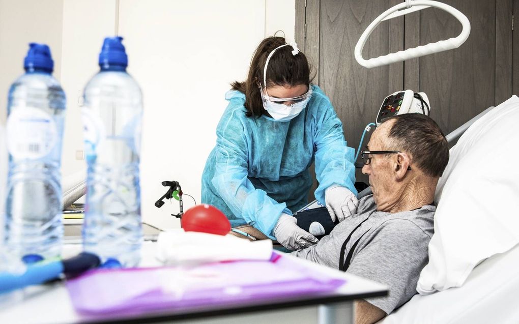 Een zorgmedewerker is aan het werk een verzorgingshuis. Zo’n 4500 leden van de RMU werken in de zorg. beeld ANP, Jeffrey Groeneweg