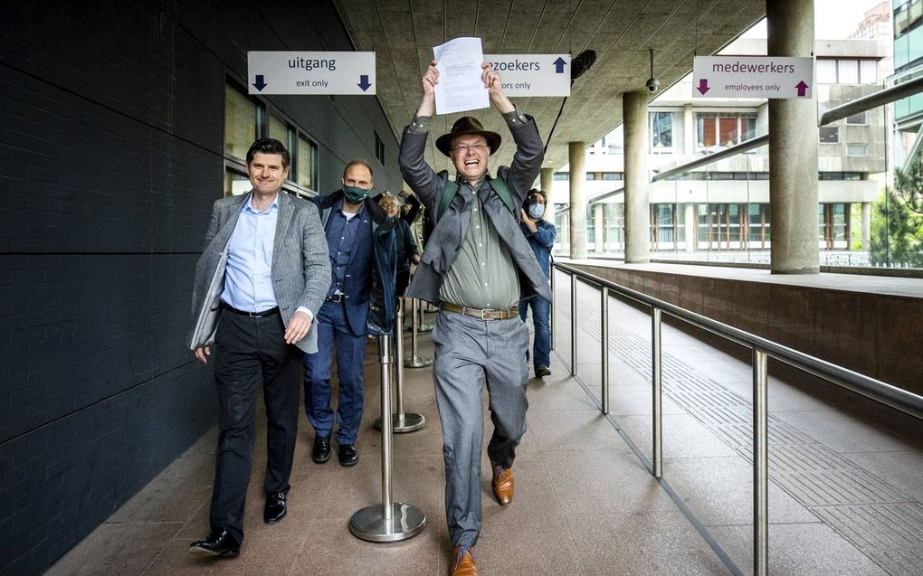 Advocaat Cox en Pols, directeur Milieudefensie, verlaten de rechtbank met de uitspraak in de hand na afloop van de klimaatzaak tegen Royal Dutch Shell. beeld ANP, Remko de Waal