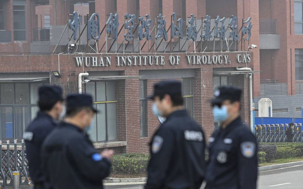 Beveiligingspersoneel bewaakt het Wuhan Institute of Virology. beeld AFP, Hector Retamal