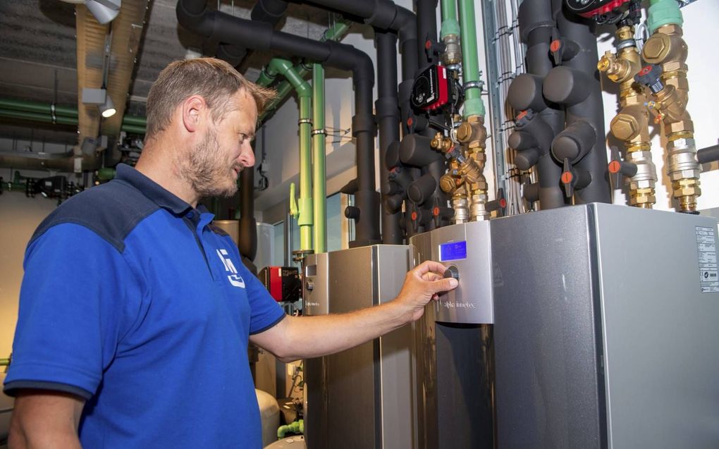 Monteur Peter Jansma bekijkt een warmtepomp. Als gediplomeerd monteur mag hij het onderhoud hiervan uitvoeren. beeld Frank Uijlenbroek