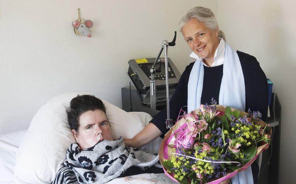 Marian Stomphorst-Vos geeft een bloemetje aan Janneke Klaassen-Arends. beeld VidiPhoto