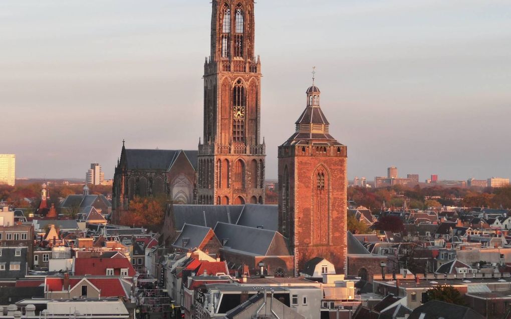 De 700-jarige Domtoren rijst hoog boven de daken van de Utrechtse binnenstad uit. Op de voorgrond de Buurkerk. Een foto van voor de restauratie die nu gaande is. beeld Wikimedia