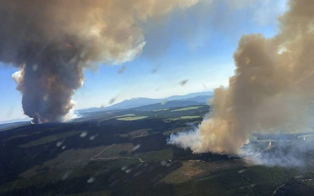 Zicht op twee natuurbranden in de Canadese provincie British Columbia, woensdag. De branden zijn ontstaan als gevolg van de extreme hitte die het westen van de Verenigde Staten en Canada teistert.  beeld AFP, BC Wildfire Service