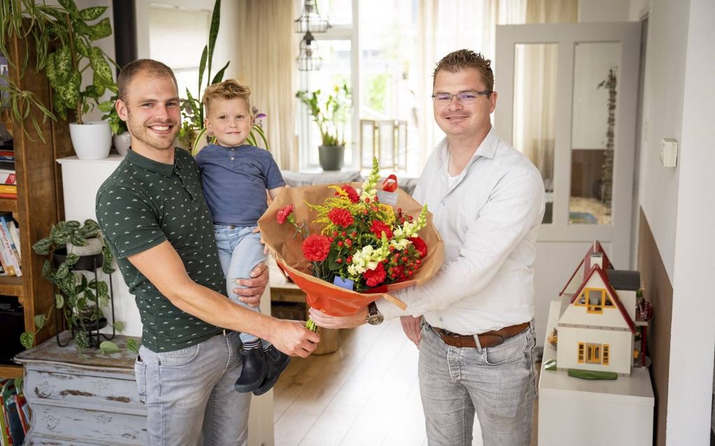 Nico van der Smit (r.) geeft een bloemetje aan Jan Corno van Burg met zoontje Silas. beeld Cees van der Wal