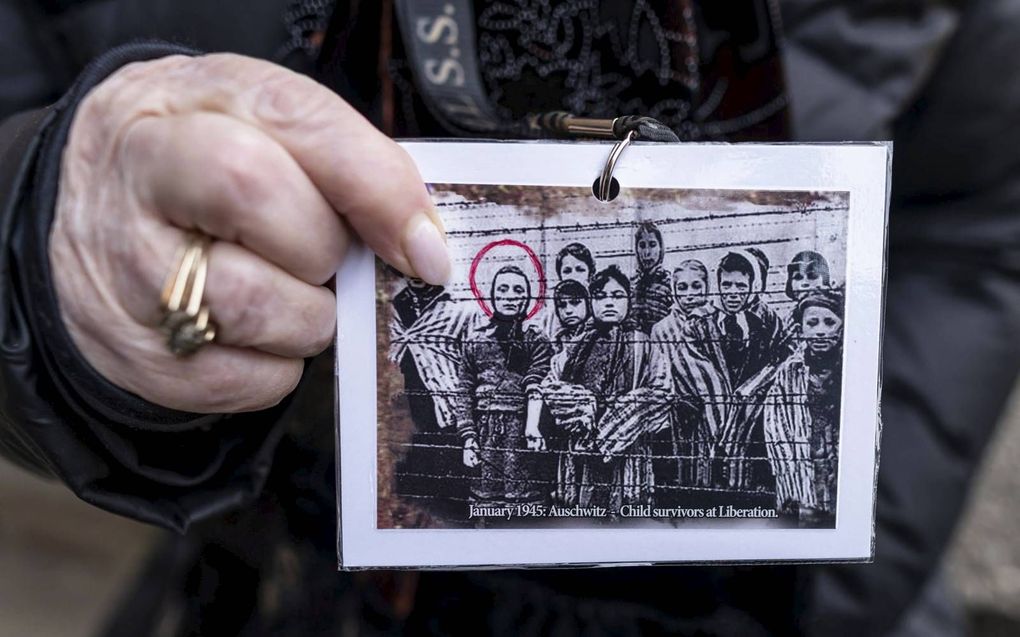 Miriam Ziegler tijdens de Holocaustherdenking vorig jaar met een foto waarop ze als kind staat. Zij overleefde de gruwelen van vernietigingskamp Auschwitz, in tegenstelling tot talloze anderen. In coronatijd zijn tal van vergelijkingen gemaakt met overheidsmaatregelen ten tijde van de Tweede Wereldoorlog. beeld AFP, Wojtek Radwanski