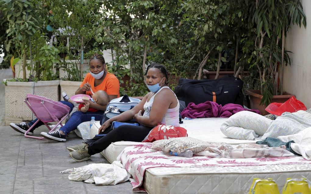 Keniaanse vrouwen zitten in de Libanese hoofdstad Beiroet voor het consulaat van hun land. Duizenden buitenlandse werkkrachten zijn door Libanezen op straat gezet en hopen dat hun land kan helpen bij het kopen van een ticket om naar huis terug te keren. beeld AFP, Anwar Amro