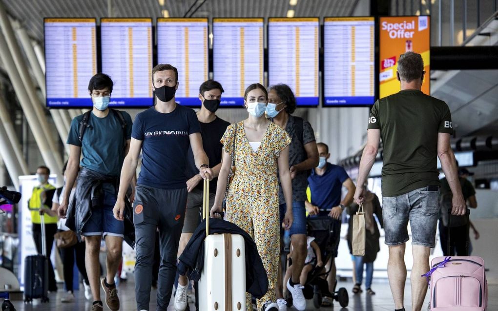 Vanwege de toename van het aantal besmettingen kleurde Nederland grotendeels rood op de Europese coronakaart, wat reizen kan bemoeilijken. Foto: vakantiegangers op vliegveld Schiphol. beeld ANP, Ramon van Flymen