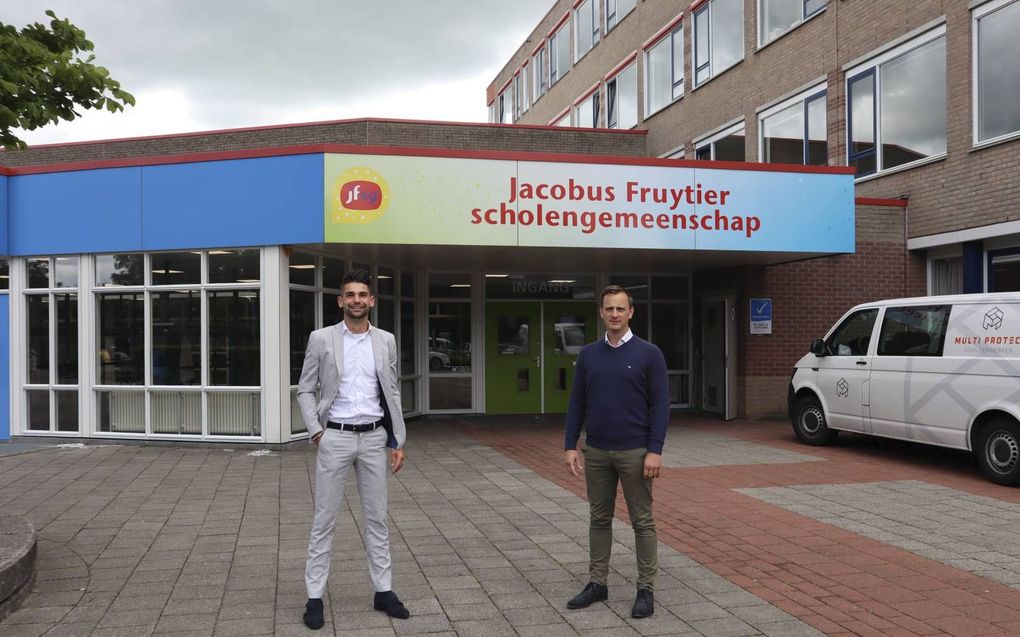 Robert-Jan Heuvelman (l) en Sieger van Looijengoed poseren voor het gebouw van het Fruytier College in Apeldoorn. beeld Bram van Lent