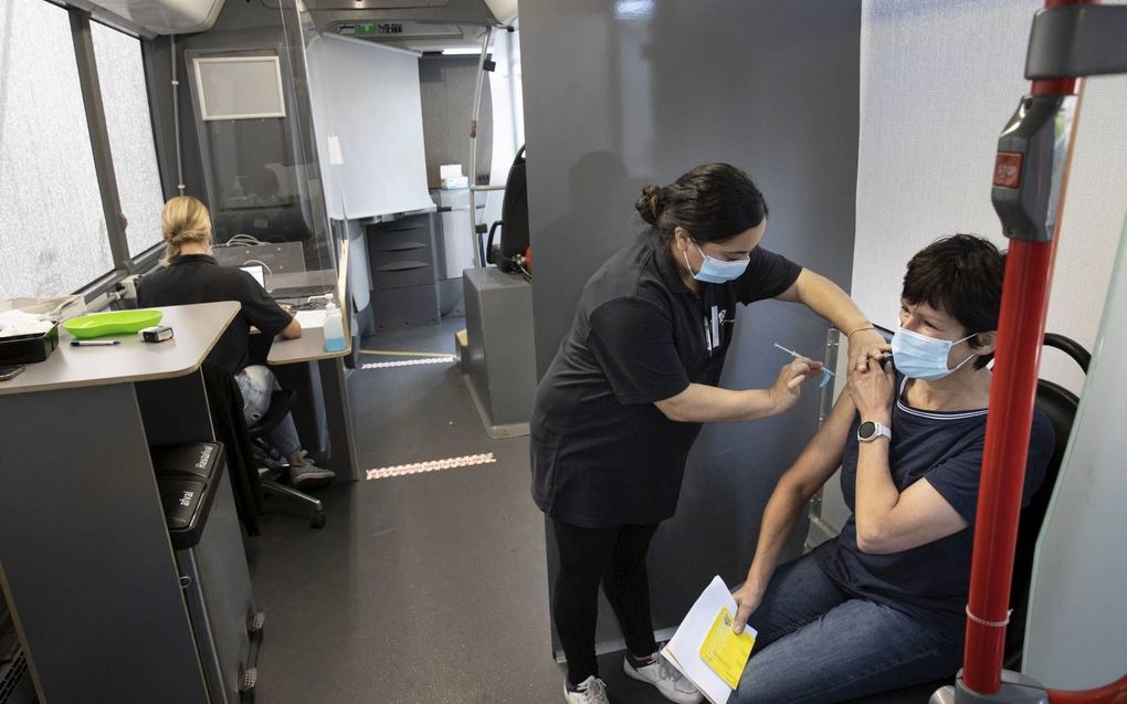 Een vrouw krijgt een prik in een vaccinatiebus, dinsdag in Lunteren. beeld RD, Anton Dommerholt