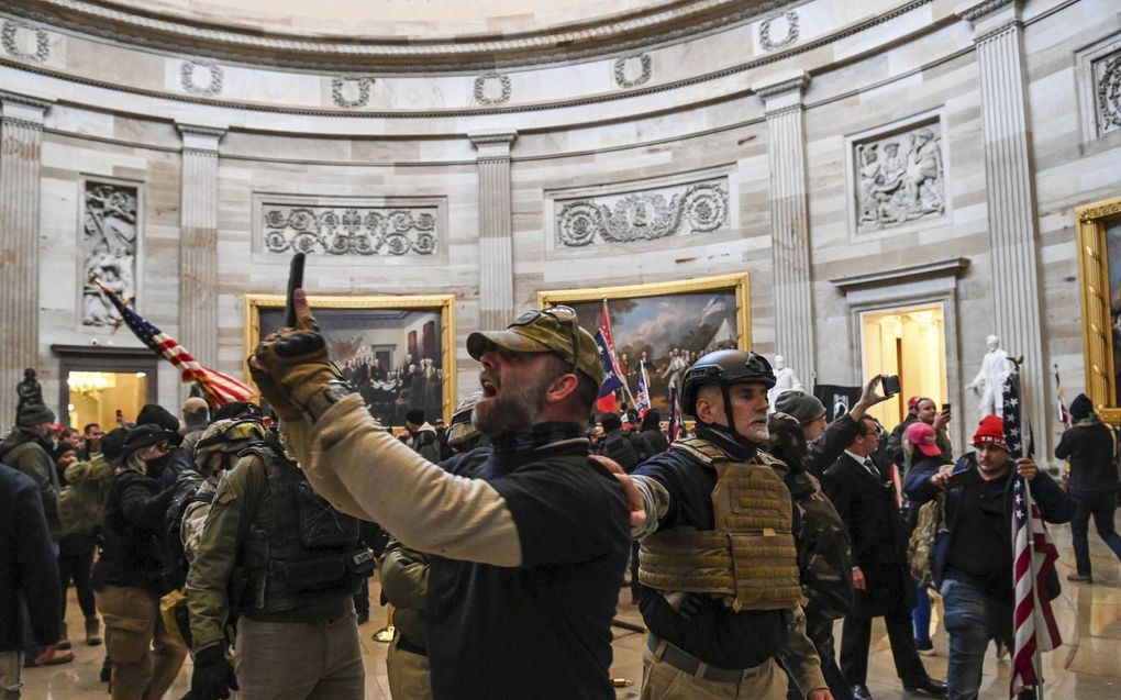 Oproerkraaiers met helmen en kogelwerende vesten bestormen op 6 januari het Capitool in Washington. beeld AFP, Saul Loeb