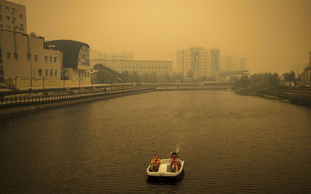 De lucht boven Jakoetsk kleurt door de bosbranden oranje. „Het is bijna niet meer te verantwoorden dat we onze kinderen deze lucht de hele zomer laten inademen.” beeld AFP, Dimitar Dilkoff