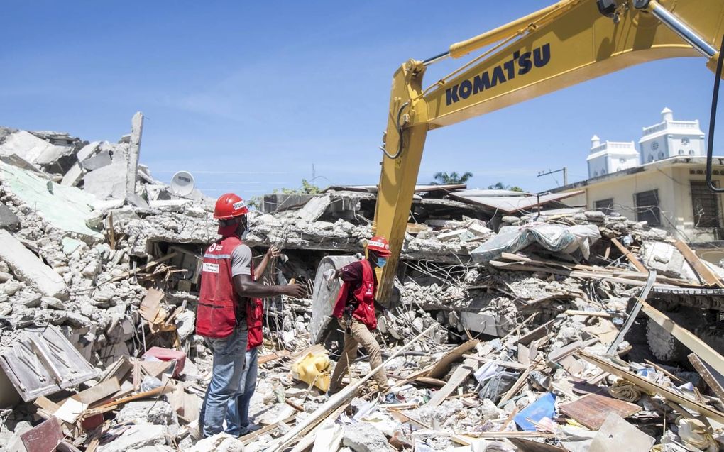 Hulpverleners zijn na de aardbeving aan het werk in de Haïtiaanse stad Les Cayes. Zeker zo’n 1300 mensen kwamen zaterdag om door het natuurgeweld.  beeld EPA, Ralph Tedy Erol