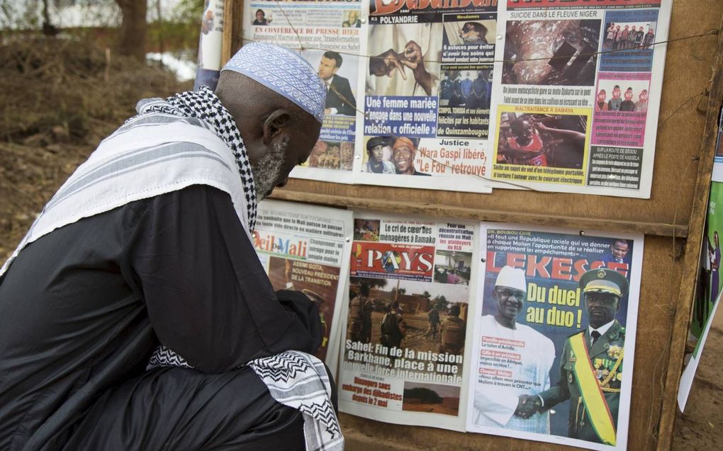 Een Malinees leest het nieuws over Franse troepenreductie in Mali, juni 2021. beeld AFP, Annie Risemberg