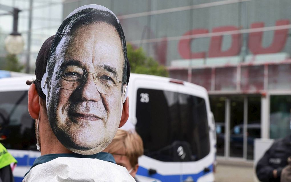 Milieuactivisten liepen dinsdag met maskers op van CDU-kanselierskandidaat Armin Laschet bij het partijbureau van de Duitse christendemocraten in Berlijn. beeld AFP, Odd Andersen