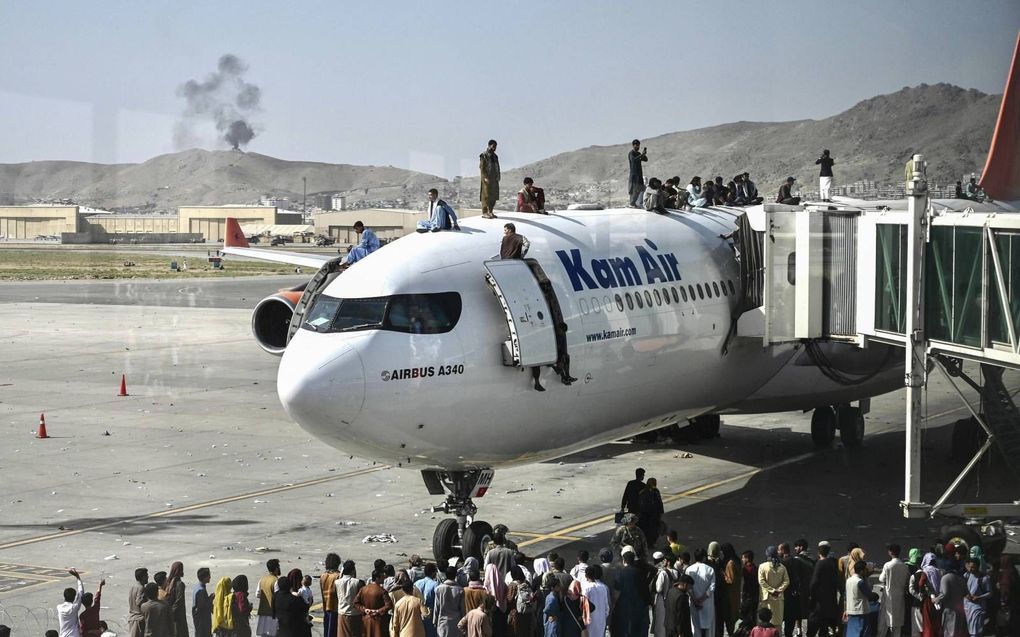 Het Afghaanse gezin Achmadi brengt een hele nacht in het donker door in de Airbus A340 van Kam Air op de luchthaven van Kabul. De situatie aan boord is onhoudbaar. „Geen elektriciteit, geen licht. Het was warm, het was vies. Er hing een enorme zweetlucht.”  beeld AFP, Wakil Koshar