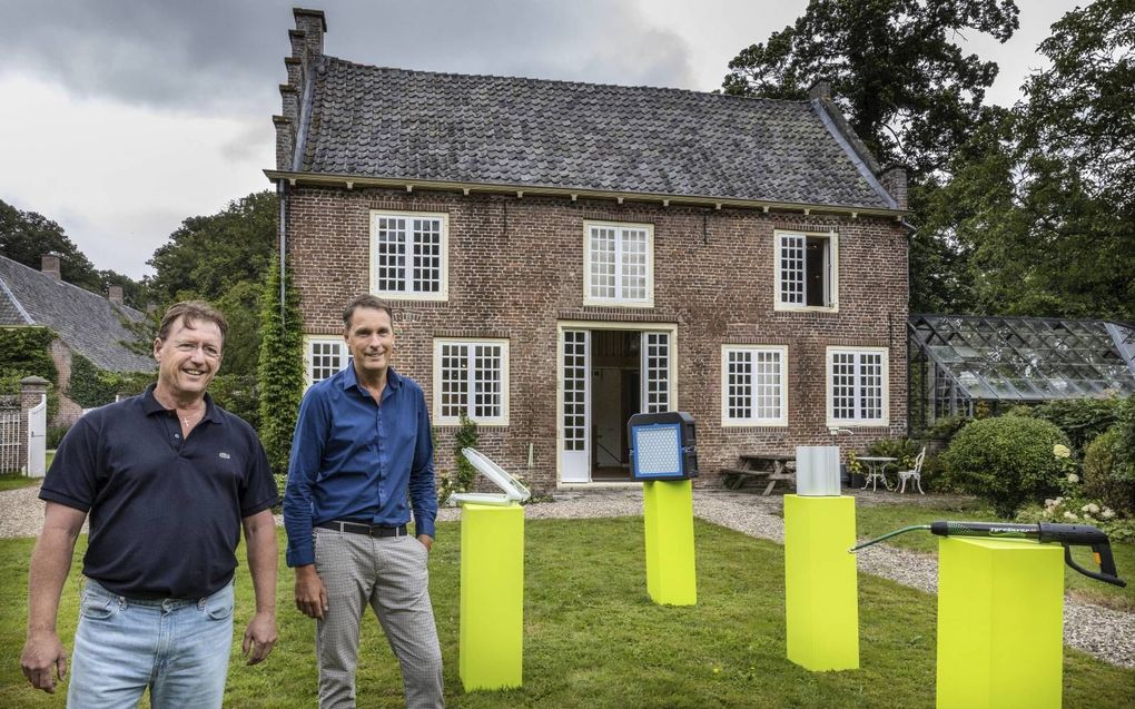 Peter Komen (links) en Jeroen Kuiper poseren voor „het meest inspirerende bedrijfspand van Nederland.” In de tuin staat voor de gelegenheid een aantal uitvindingen opgesteld. beeld RD, Henk Visscher