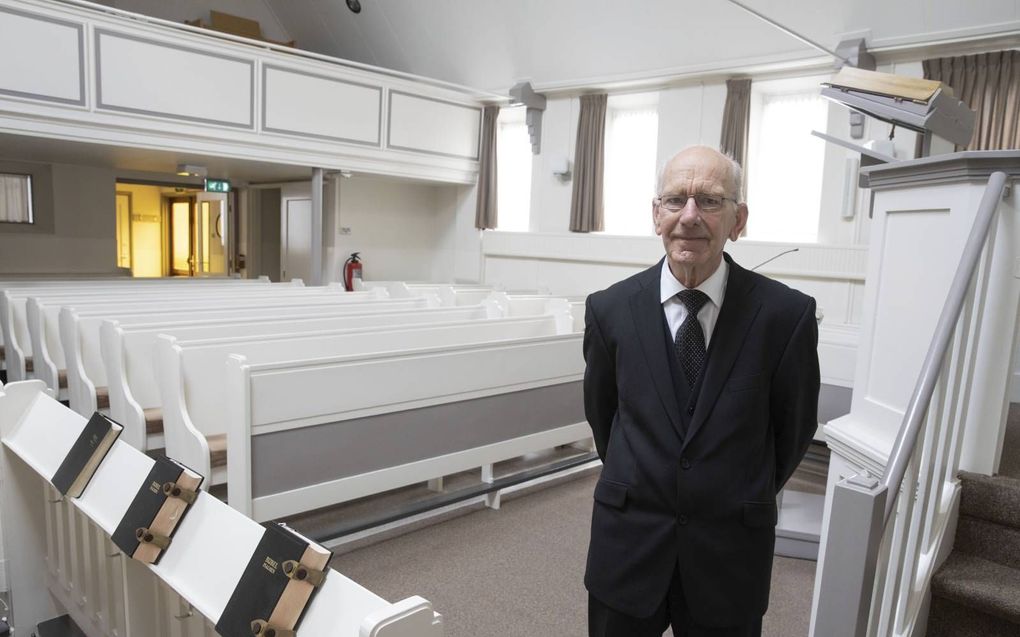 Koster Van der Sluijs, 50 jaar in functie in de gereformeerde gemeente van Oude-Tonge. Zoutwerking in de muren van het kerkje herinnert aan de ramp van 1953. beeld RD, Anton Dommerholt