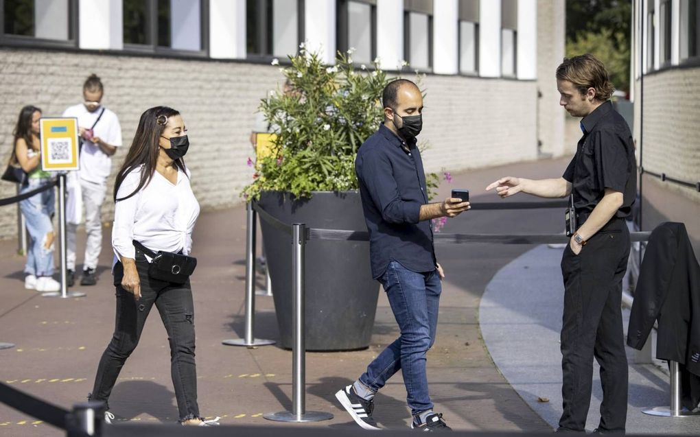 Bezoekers bij het Van Goghmuseum in Amsterdam met hun mobiele telefoon. Er zijn veel vragen en twijfels bij het kabinetsplan voor de bredere inzet van coronatoegangsbewijzen. beeld ANP, Ramon van Flymen