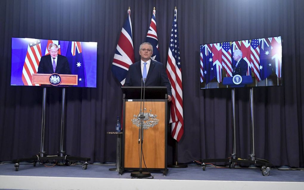 De Australische premier Scott Morrison (m.), donderdag tijdens een persconferentie over het Aukus-pact in Canberra. Links van hem op het scherm de Britse premier Boris Johnson, rechts de Amerikaanse president Joe Biden. beeld EPA, Mick Tsikas