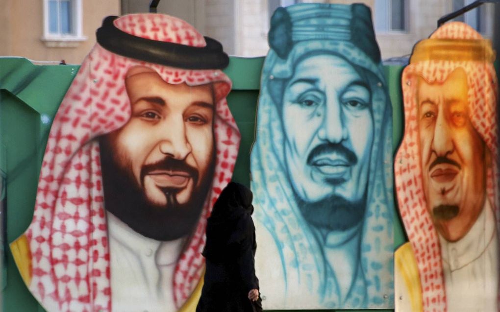 Een vrouw loopt in Dammam langs een metershoge afbeelden van Mohammed bin Salman (links), kroonprins van Saudi-Arabië, en diens vader en grootvader. beeld AP, Amr Nabil