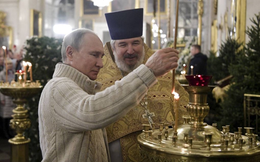 President Vladimir Poetin steekt een kaars aan tijdens een kerstviering in een Russisch-orthodoxe kerk. beeld AFP, Alexey Nikolsky