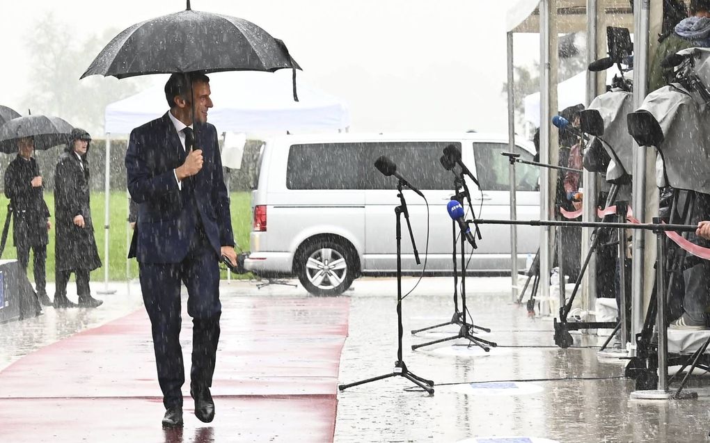 De Franse president Emmanuel Macron arriveert in de stromende regen op de EU-top met de westelijke Balkanlanden, woensdag. Slovenië, dat dit halfjaar de EU voorzit, wilde afspreken dat de landen vóór 2030 zouden mogen toetreden tot de Unie. beeld AFP, Joe Klamar