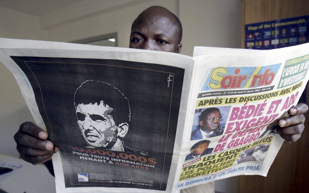 Een man leest een Ivoriaanse krant die in 2005 een advertentie publiceerde waarin een beloning van 10 miljoen dollar wordt uitgeloofd voor informatie over de vermiste Israëlische vlieger Ron Arad. beeld AFP, Issouf Sanogo