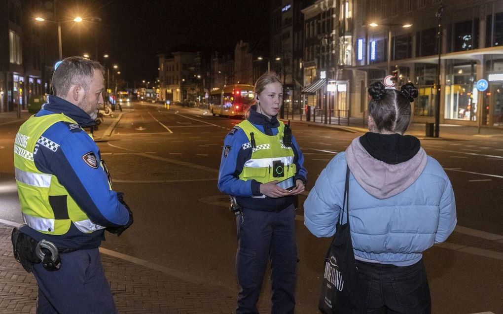 Handhavers in de binnenstad van Utrecht controleren mensen die tijdens de avondklok op straat zijn. In het KPMG-rapport over de overheidsaanpak van de coronacrisis wordt de avondklok genoemd als succesvol voorbeeld van een tijdig genomen voorzorgsmaatregel. beeld Erik Kottier