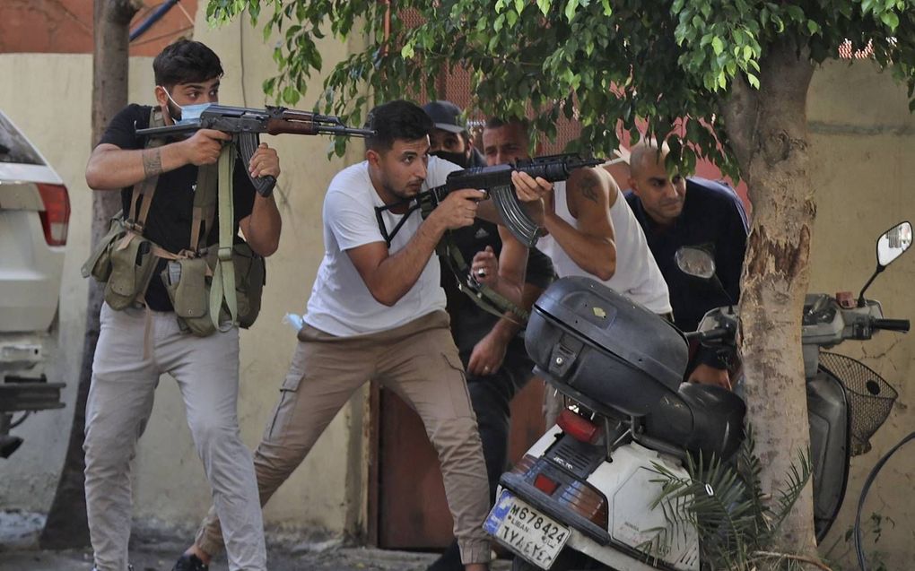 Strijders van Hezbollah en Amal schieten donderdag op rivalen die hen vanaf daken onder vuur nemen in Beiroet. beeld AFP, Anwar Amro