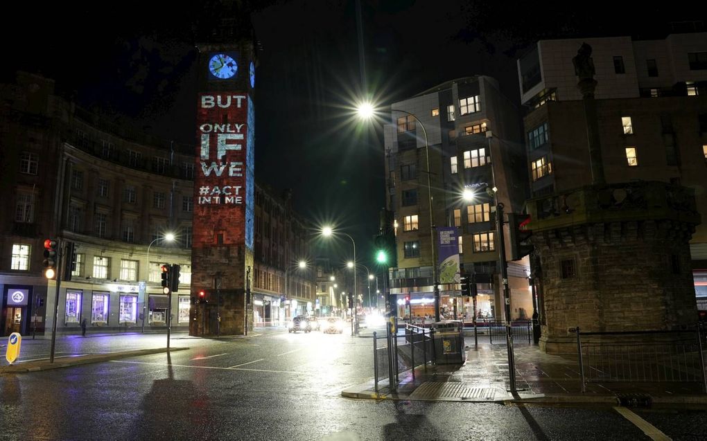 De onderhandelingen tijdens de klimaattop in Glasgow zijn in de laatste, spannende fase terechtgekomen. Foto: Een projectie op de klokkentoren Tolbooth Steeple in Glasgow. De klimaatklok tikt.  beeld AP, Alastair Grant