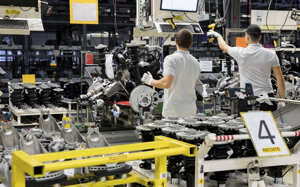 Medewerkers bij een assemblagelijn bij VDL Nedcar in Born. De autofabrikant moest de productie al meerdere keren stilleggen vanwege het chiptekort. beeld ANP, Niels Wenstedt