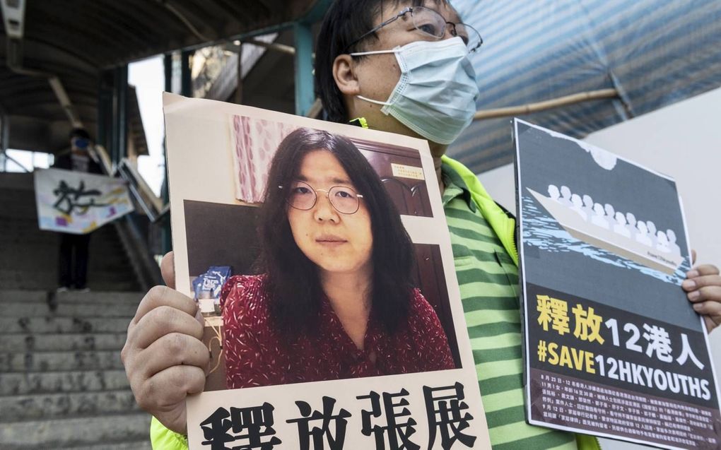 Een activist in Hongkong protesteert met een poster van Zhang Zhan. beeld EPA, Miguel Candela