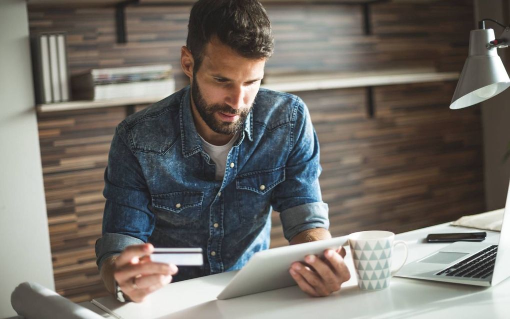 Een man controleert zijn bankrekening. Sommige mensen en organisaties verliezen hun rekening als gevolg van antiwitwasregels. beeld iStock​