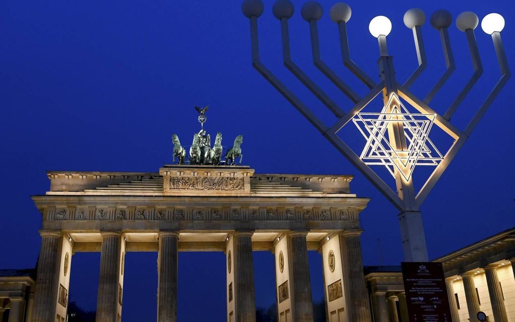 Een grote kandelaar wordt ieder jaar bij het Joodse feest chanoeka bij de Brandenburger Tor in Berlijn geplaatst. beeld EPA, Filip Singer