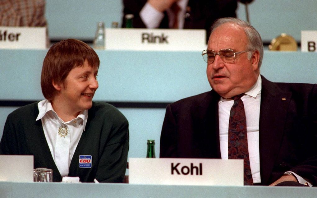 De Duitse bondskanselier Helmut Kohl in gesprek met Angela Merkel tijdens een partijconferentie in 1991 in Dresden. Aanvankelijk werd Merkel denigrerend het meisje van Kohl genoemd. beeld EPA, Michael Jung