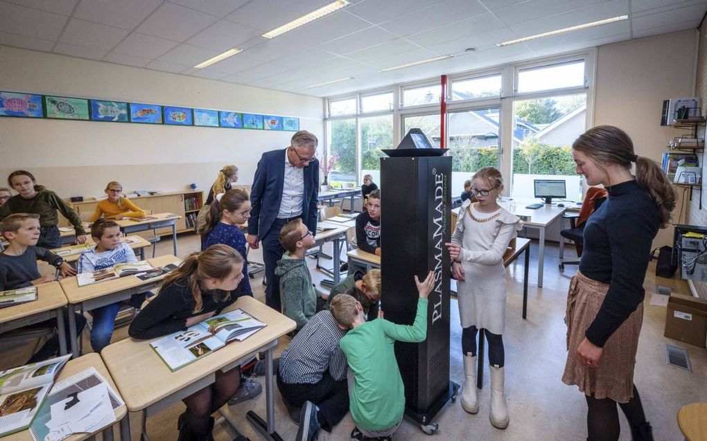 Alle basisscholen in Staphorst hebben samen honderden AirCleaners van PlasmaMade ontvangen. Directeur Jan Kuijers (m.) van de Koning Willem-Alexanderschool in Staphorst noemt de filters „dé oplossing!” De ramen kunnen dicht; dat scheelt een trui. beeld ANP/Hollandse Hoogte, Wilbert Bijzitter