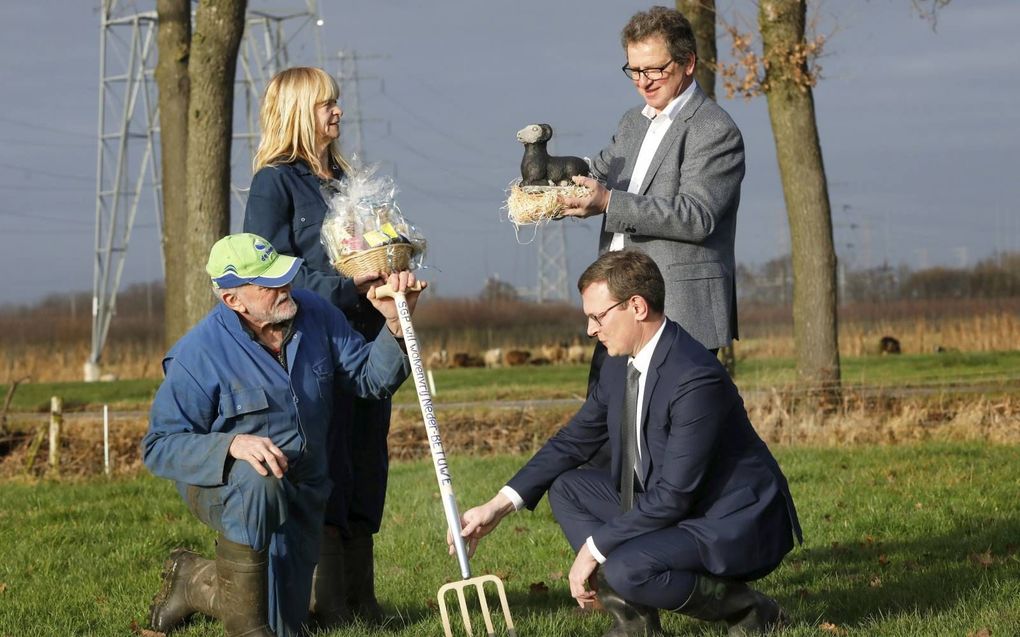 Dirk en Goudje van der Grift uit Hemmen (l.), wier schapen door een wolf werden aangevallen, en SGP-politici Arends en Van Nifterik wisselen symbolische geschenken uit. beeld VidiPhoto