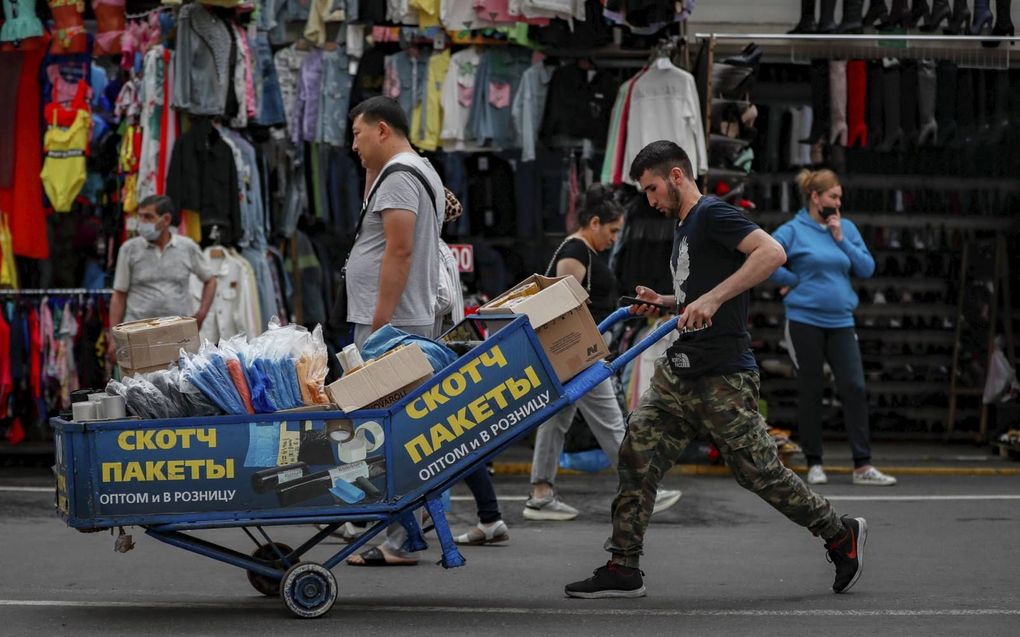 Arbeidsmigranten aan het werk op een markt in de Russische hoofdstad Moskou. beeld EPA, Yuri Kochetkov