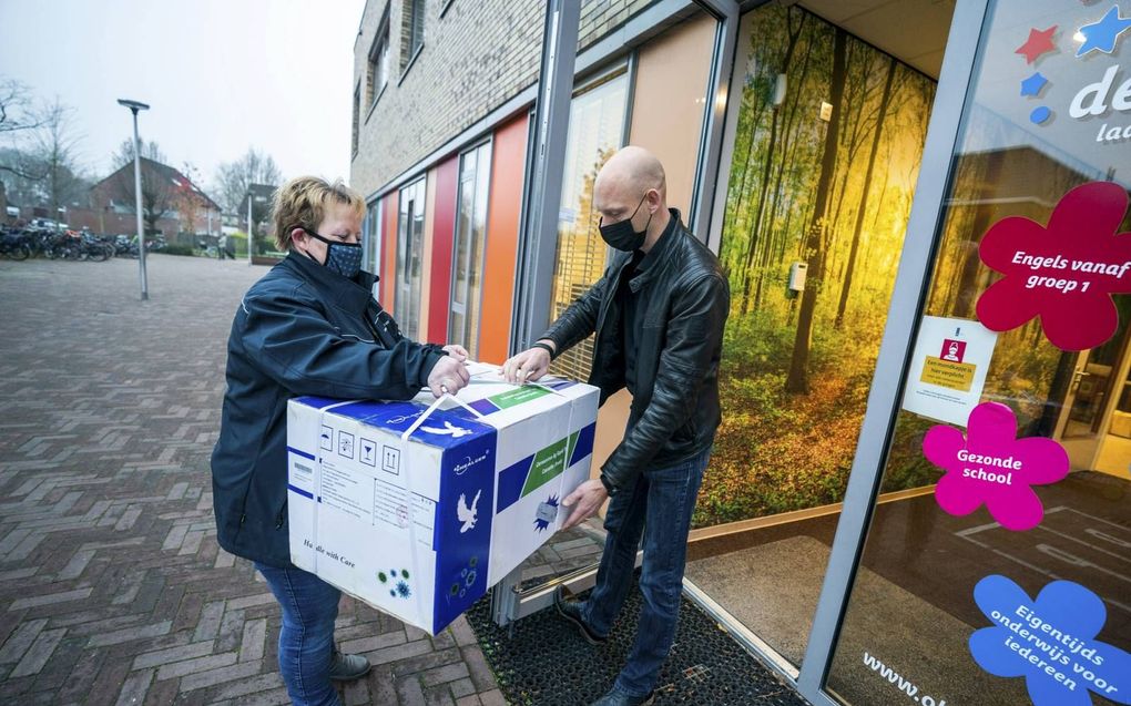 Ladingen met coronazelftests worden afgeleverd bij een basisschool. Een slimme teststrategie kan helpen om het aantal besmettingen binnen de perken te houden. beeld ANP, Jeroen Jumelet