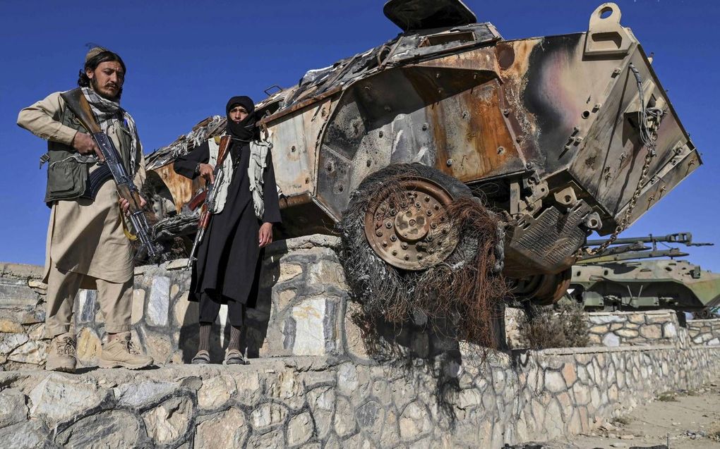 Talibanstrijders nemen een kijkje bij de informele tentoonstelling. beeld AFP, Hector Retamal