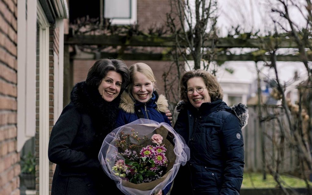 Petra Kosters (r.) geeft een bloemetje aan haar schoonzus Ingrid Immink (l.) omdat zij zo veel over heeft voor haar nichtje Sophie (m.). beeld Speechless Photography