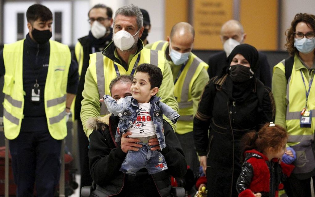 Munzir el-Nezzel arriveerde met zijn gezin afgelopen vrijdag op de luchthaven van Rome. Op schoot zit zijn zoon Mustafa.  beeld EPA, Frabio di Pietro