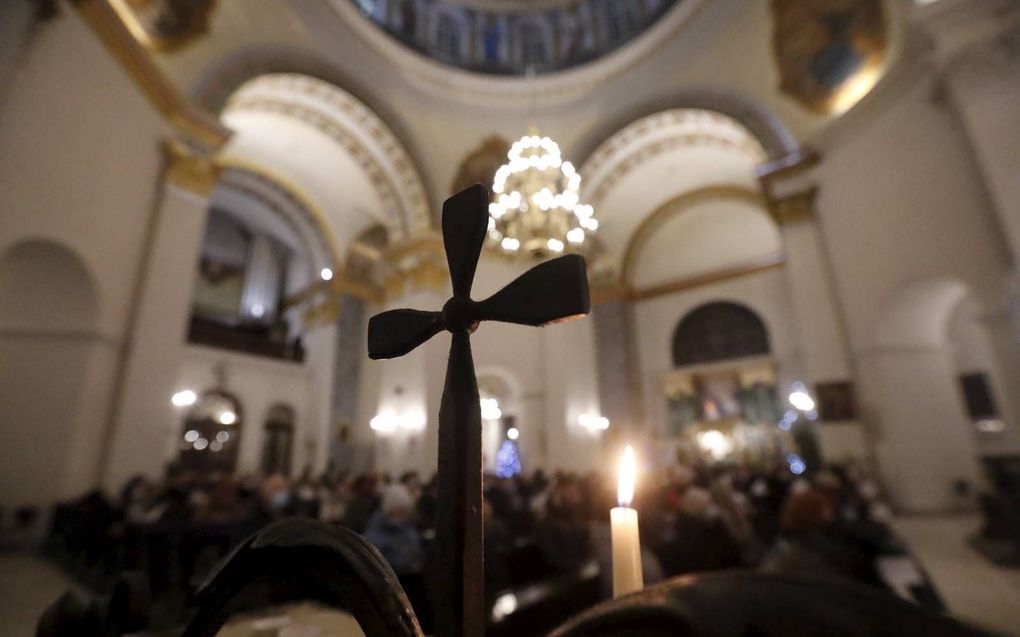 Inwoners van de Oekraïense hoofdstad Kiev woonden woensdag een gebedsdienst voor vrede bij in de rooms-katholieke St. Alexander kerk. Al wekenlang dreigt een Russische invasie in Oekraïne. beeld EPA, Zurab Kurtskidze