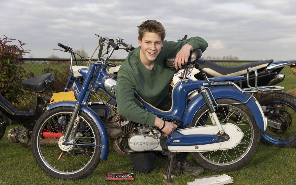 Gideon Oudenaarden met zijn Sparta Tour met Saxonette motor. Op de achtergrond zijn andere brommers. beeld Martin Droog