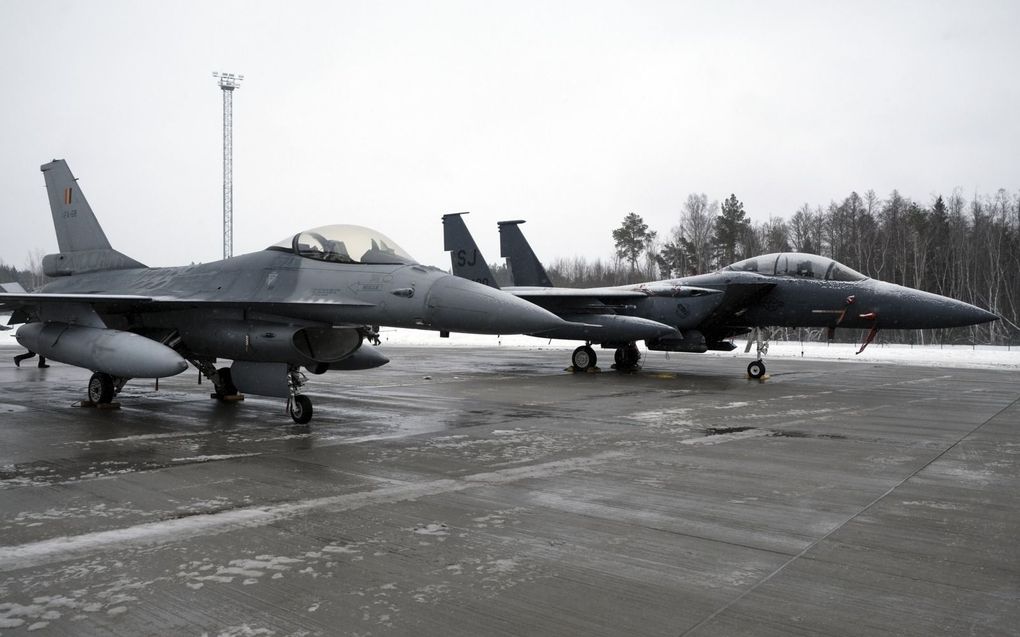 Een Belgische F16 (l.) en een Amerikaanse F-15 op een NAVO-basis in Estland. beeld EPA, Valda Kalnina