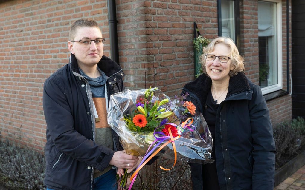 Bernhard Lokhorst (24) geeft Coby van Ommeren-Noorland (61) een bloemetje omdat zij voor hem „een tweede moeder is.”  beeld Anton Dommerholt