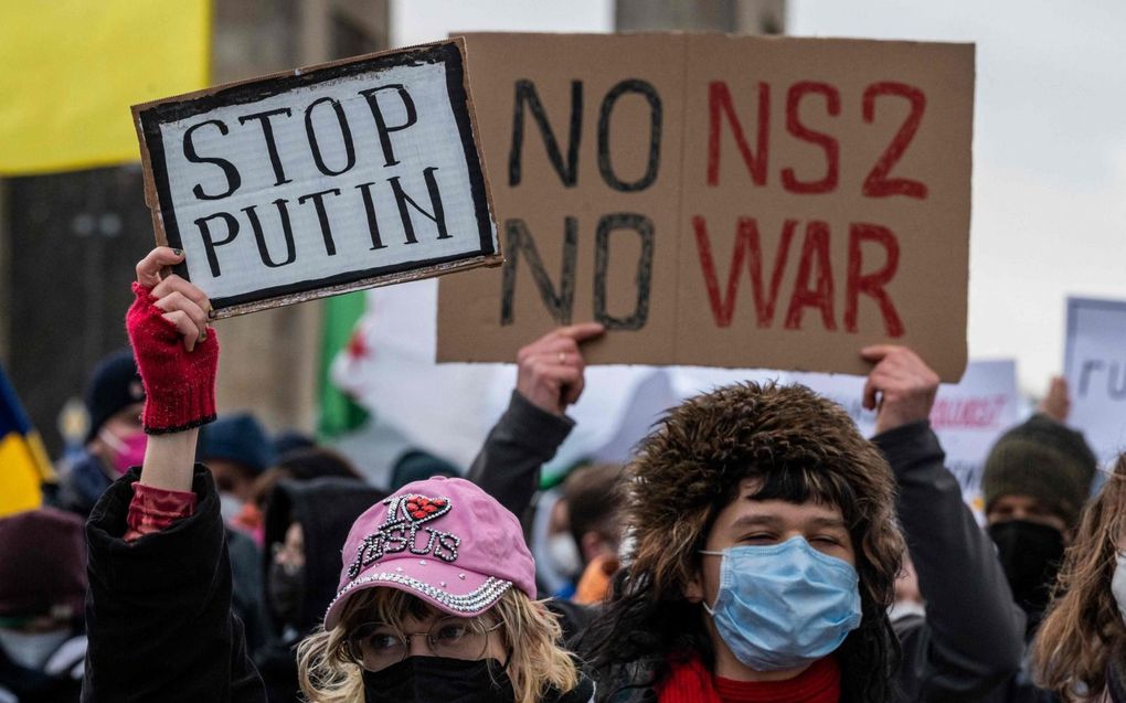 Een betoger houdt een bord omhoog met de tekst ”Geen Nord Stream2” tijdens een protestmars begin deze week bij de Brandenburger Tor in Berlijn. De demonstranten riepen de Duitse regering op meer op te komen voor de Oekraïense belangen. beeld AFP, John MacDougall