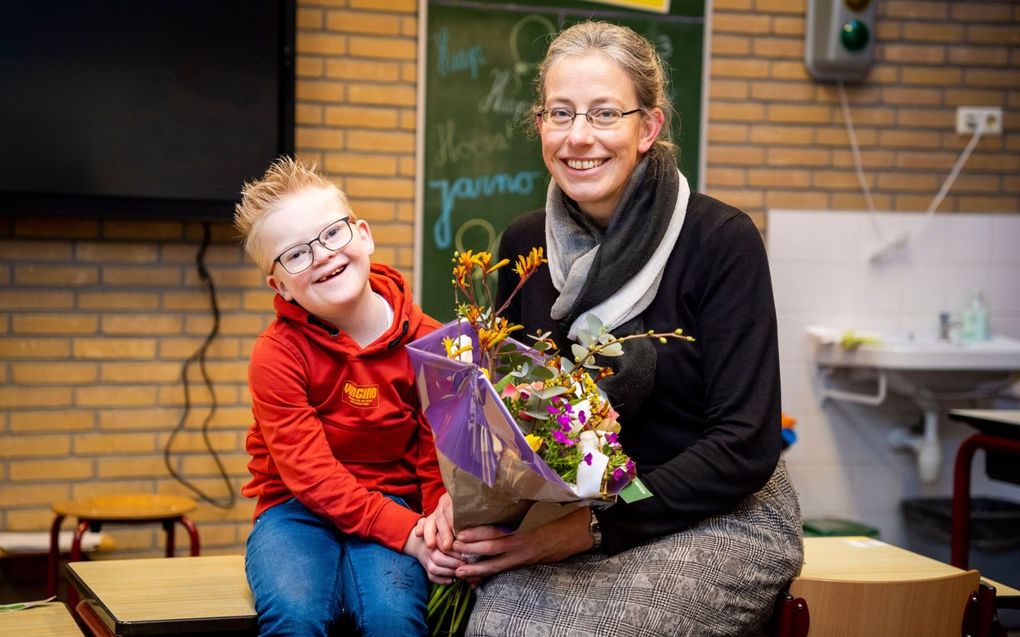 Jari Oskam (9) geeft juf Josina van Dijk (47) een bloemetje als dank voor de liefdevolle begeleiding op de Johannes Calvijnschool in Leerdam. beeld Cees van der Wal