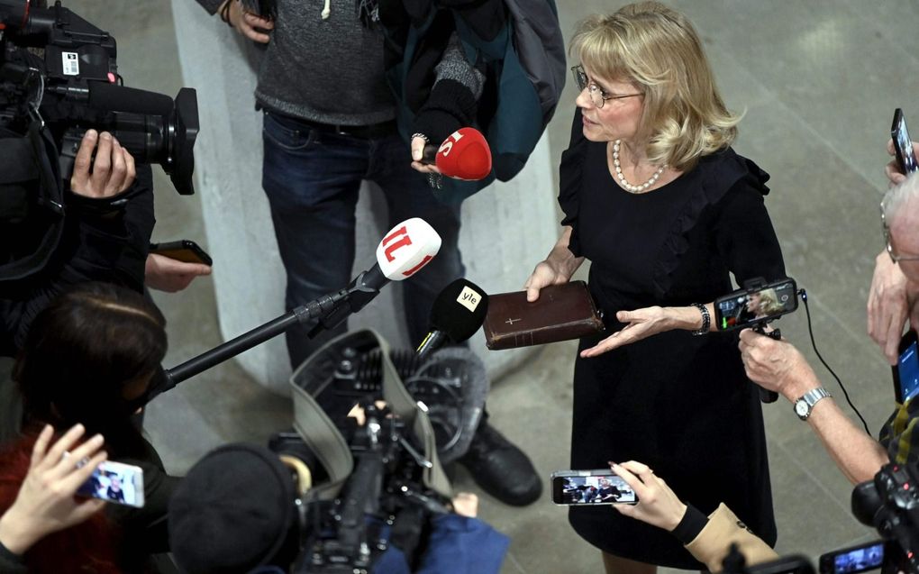 De Finse politica Päivi Räsänen staat, met de Bijbel in de hand, journalisten te woord over haar uitspraken rond homoseksualiteit. beeld AFP