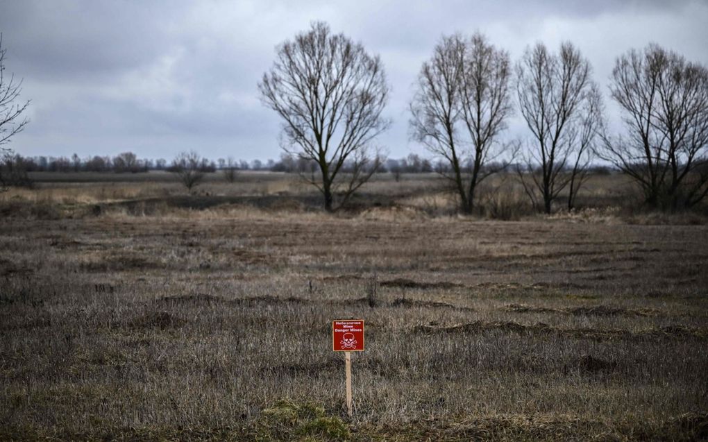 Landbouwgrond niet ver van Kiev. Het bordje waarschuwt dat er mijnen liggen. beeld AFP, Aris Messinis